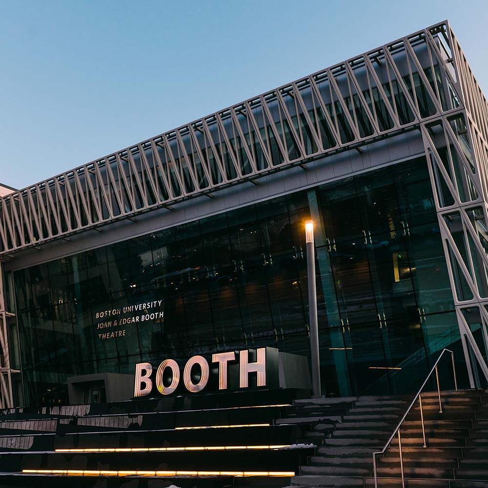 Photo of Booth Theatre in 2019. The building has steps towards a lit sign that says "Booth"; the building facade is glass with metal beams criss-crossing around the top and sides.