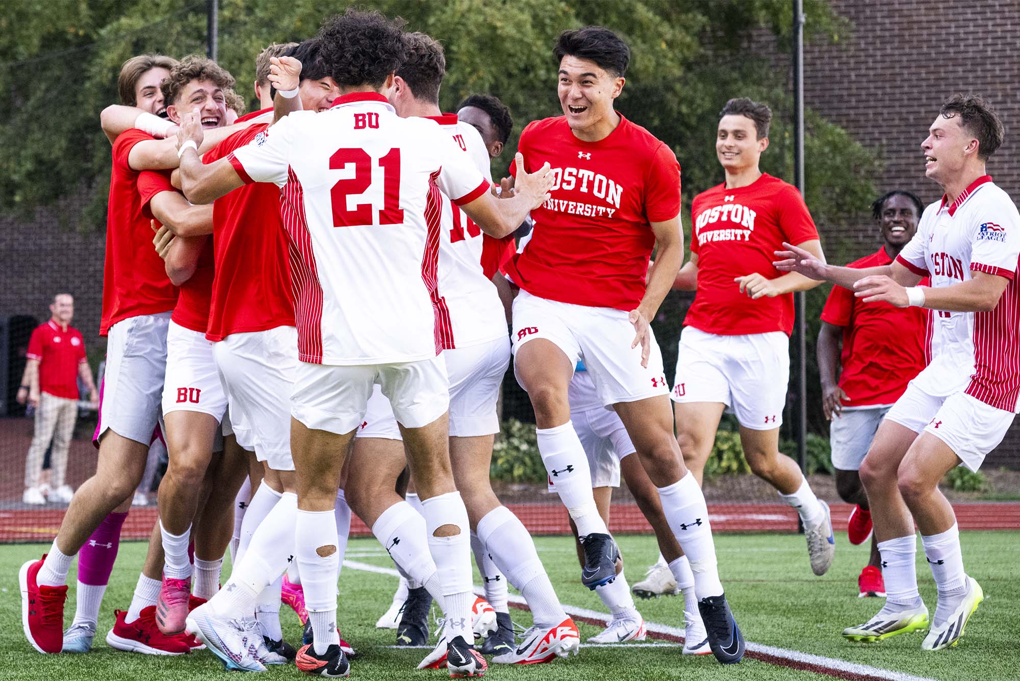 Photo: A group of college soccer players celebrate together after a win in red and white uniforms