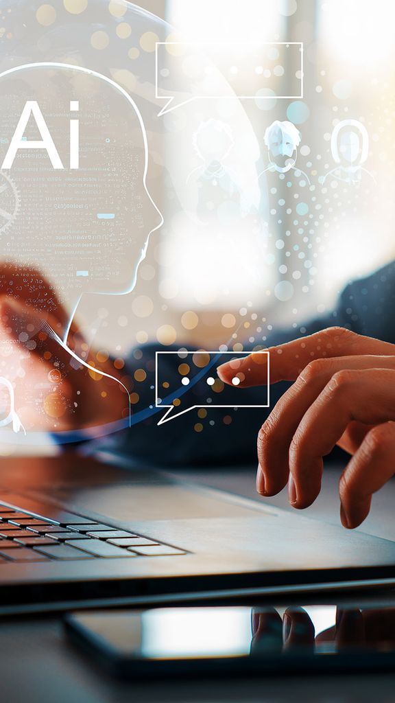 Photo: The concept of artificial intelligence and computer technology is shown with a photo of a person typing on a black laptop. AI techno-themed illustrations hover above the hands as they type, signifying the use of AI.