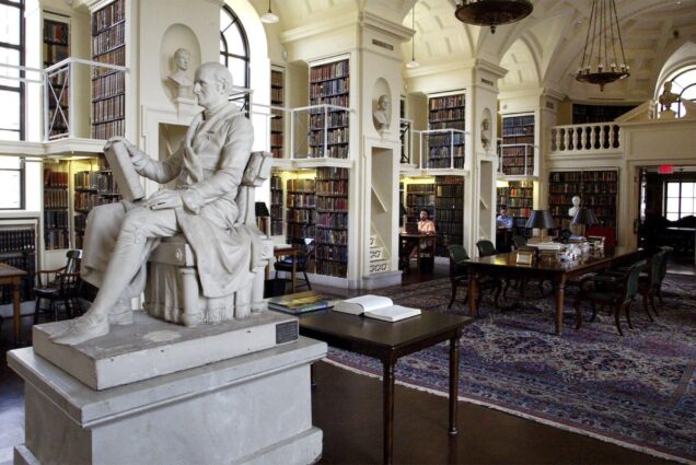 Photo: An ornate library with many books are wood/stone carvings