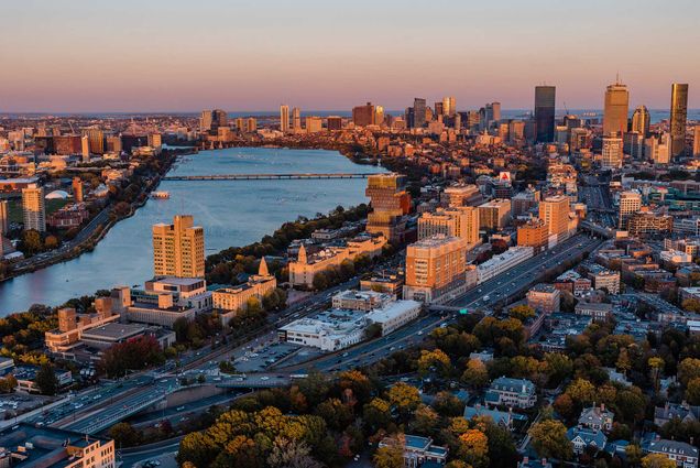 Photo: Aerial shot of Boston University's campus during sunset. An orange glow is shown on the large campus highlighting campus buildings like Kilachand.