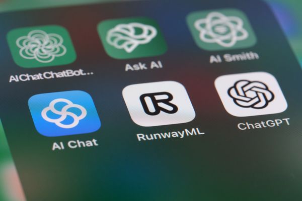 Image: A zoomed in photo of a phone screen showing icons for OpenAI ChatGPT and other AI application software.