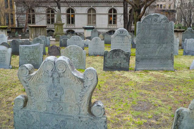 Photo: A stock image of a graveyard. The headstones are old and eclectic and the ground is patchy grass.