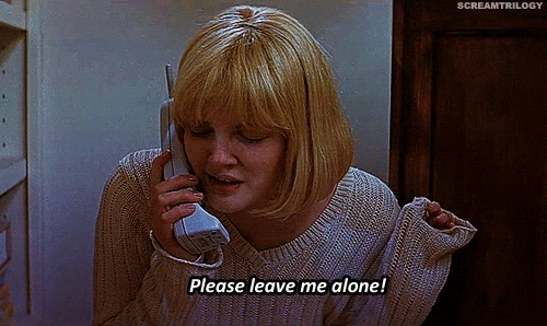 This is a GIF from the sixth Scream movie. The actress has a blonde, short, bob haircut and has pale skin. She's in a tan/pink-ish v-neck knit sweater. In one hand, she has a old-style white, cordless phone up to her ear. Her other arm is up by her shoulder and she is nervously fidgeting with the edges of her sweater. She is talking into the phone nervously with her eyes closed. There is a caption at the bottom of the GIF that says "Please leave me alone!" which mimics the words she is saying.
