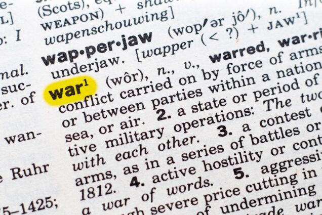 Photo: Closeup shot of a dictionary page opened up to the entry for the word "war". The word "war" is highlighted in neon yellow.