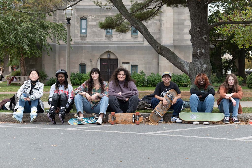 Photo: The BU Girls' Skateboarding Club poses for a photo along the BU Beach, an outdoor area where BU students can relax and unwind outside.