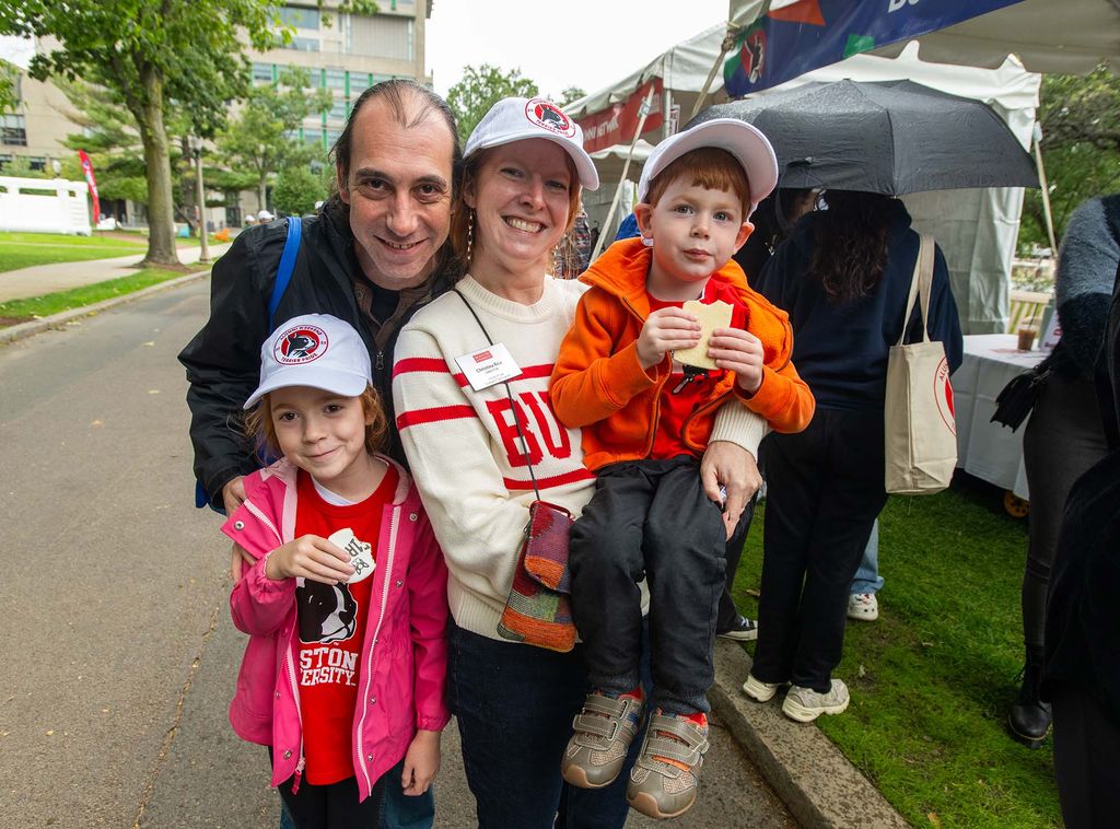 Photo: A family wearing casual outfits and BU shirts pose together for a photo on a overcast day.