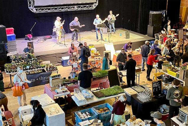 Photo: A band plays on a stage in front of an indoor winter market full of people in Somerville, MA