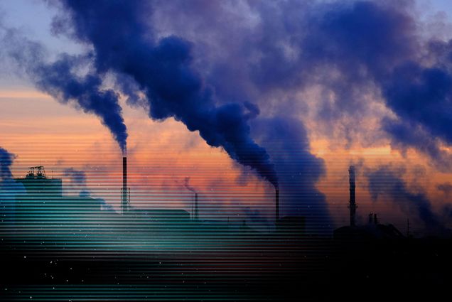 Photo: Steam rises from a large power plant as the sun rises behind the fog