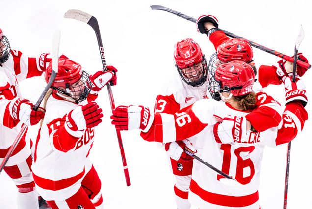 Photo: A group of women's hockey players hug each other after scoring a goal at a recent game