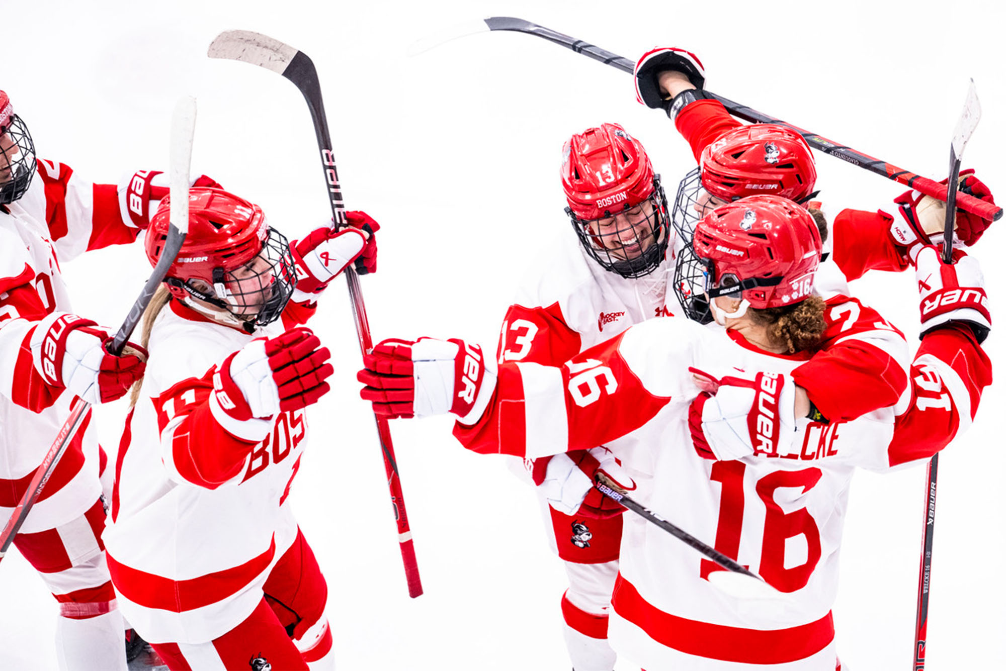 Photo: A group of women's hockey players hug each other after scoring a goal at a recent game