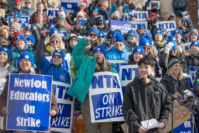 Photo: A large group of teachers on strike in Newton MA, holding blue signs that read "Newton Educators on Strike"