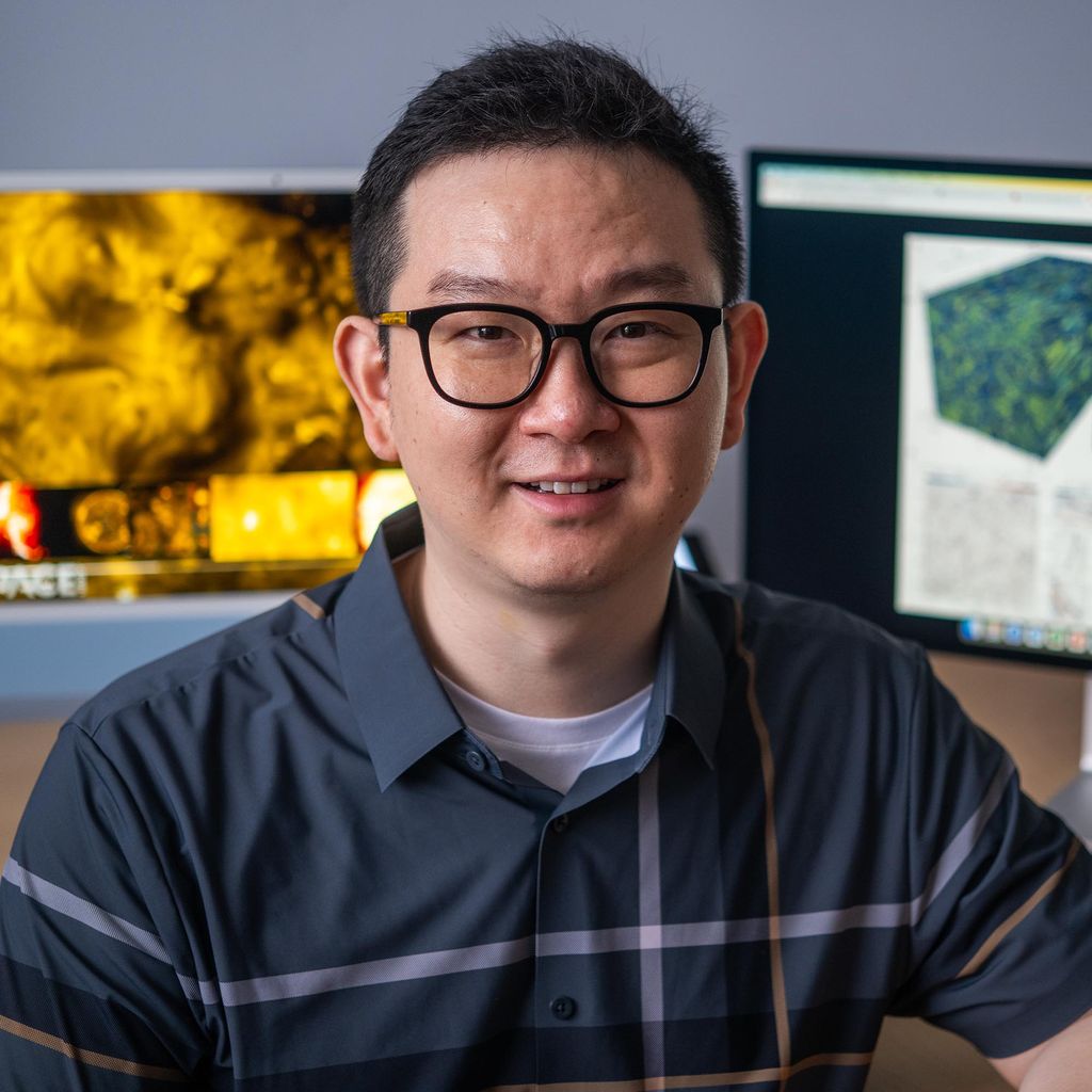 Photo: Chuanfei Dong, a man with short dark hair, glasses, and a collared cotton shirt.