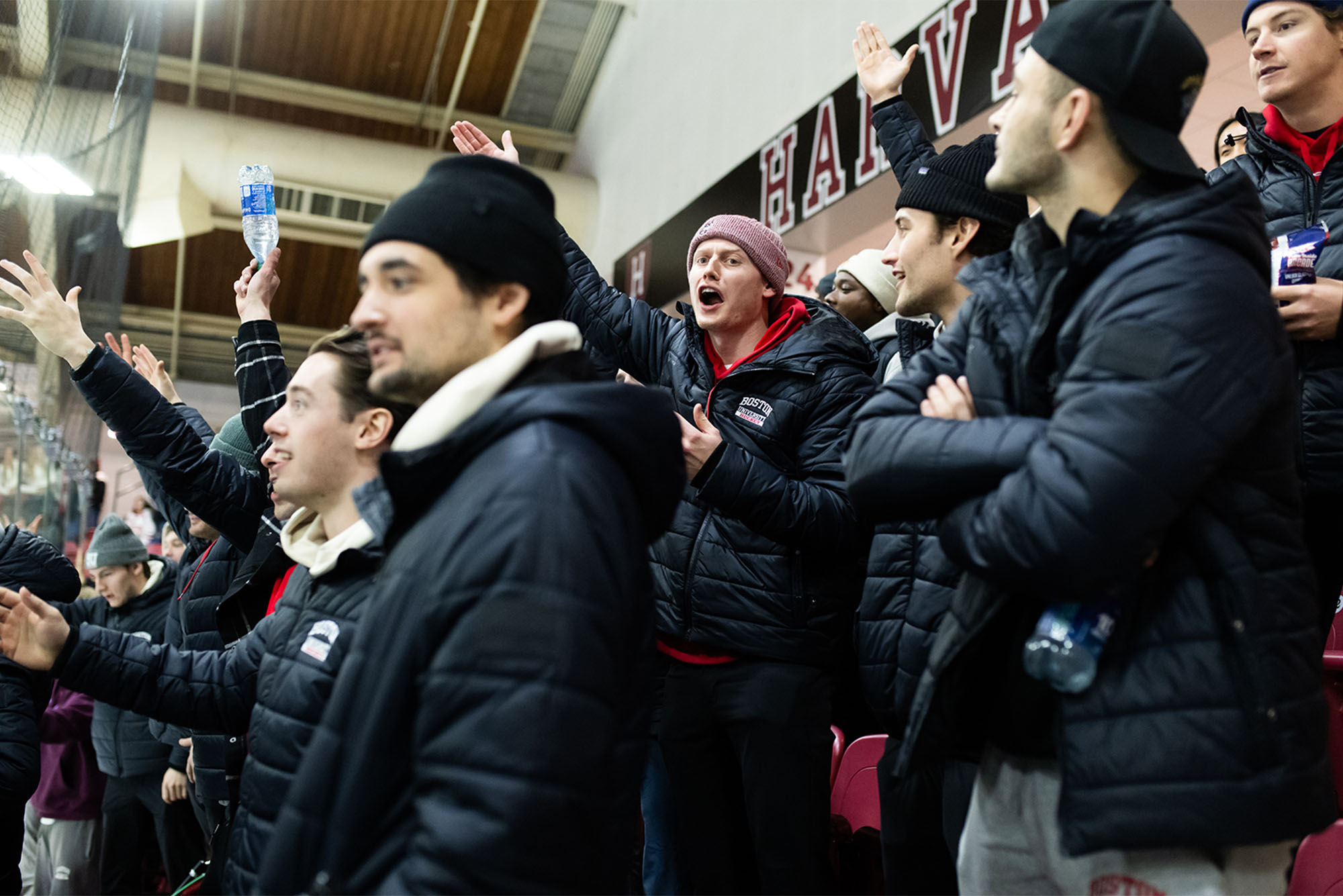 Photo: The BU Men's hockey team in matching black jackets cheer on the women's hockey team at the beanpot semifinal