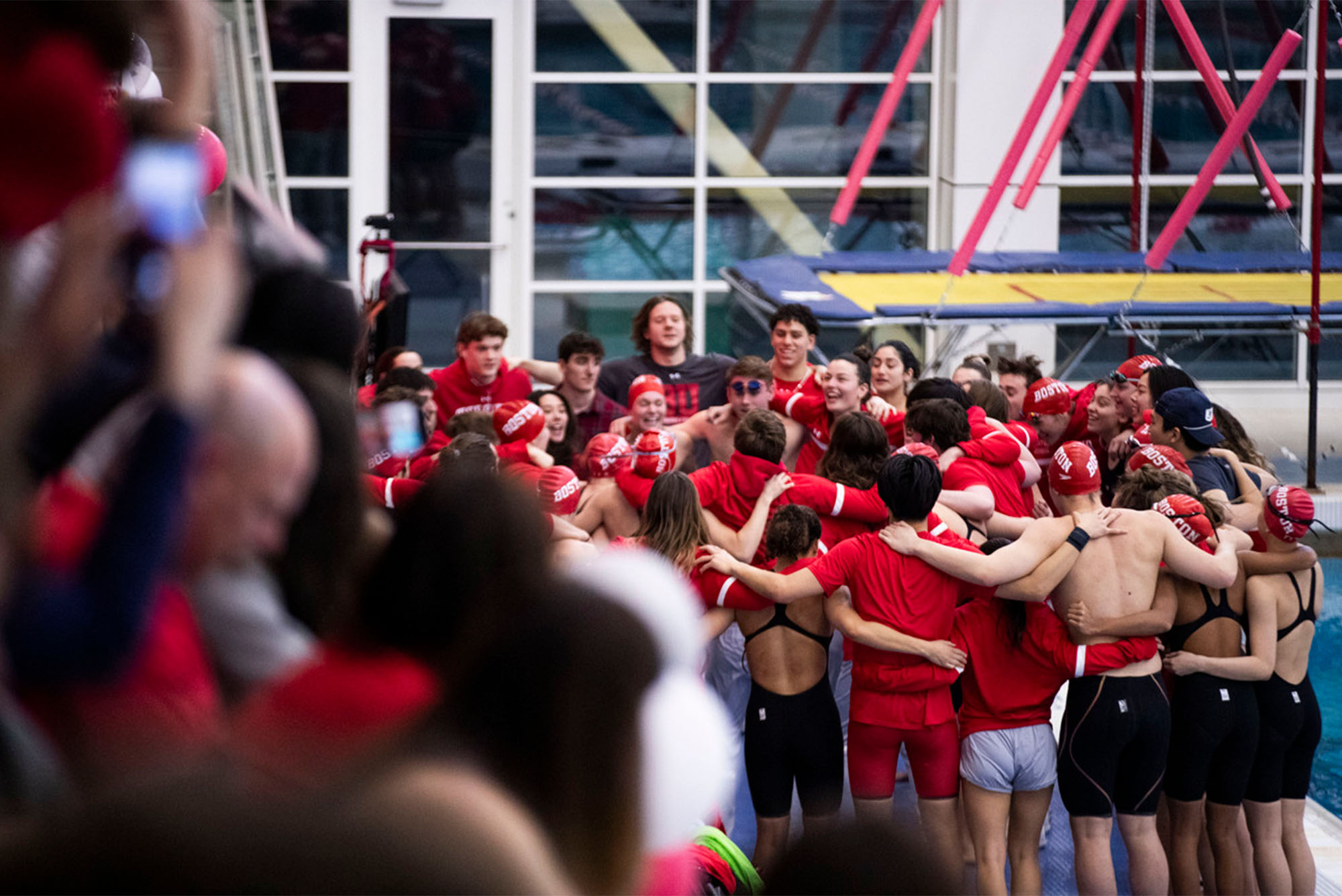 Photo: A large group of college students on the Boston University Swim and Dive team gather in a large group at a recent meet