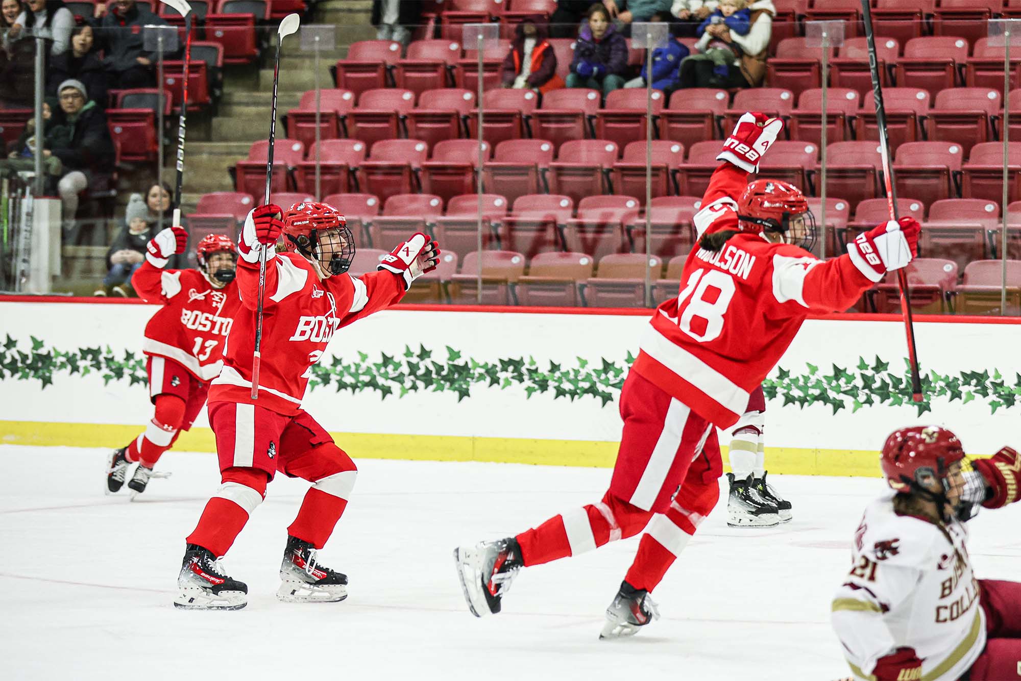 Photo: A group of women's hockey players in red and white jerseys celebrate after a goal during the beanpot semifinals