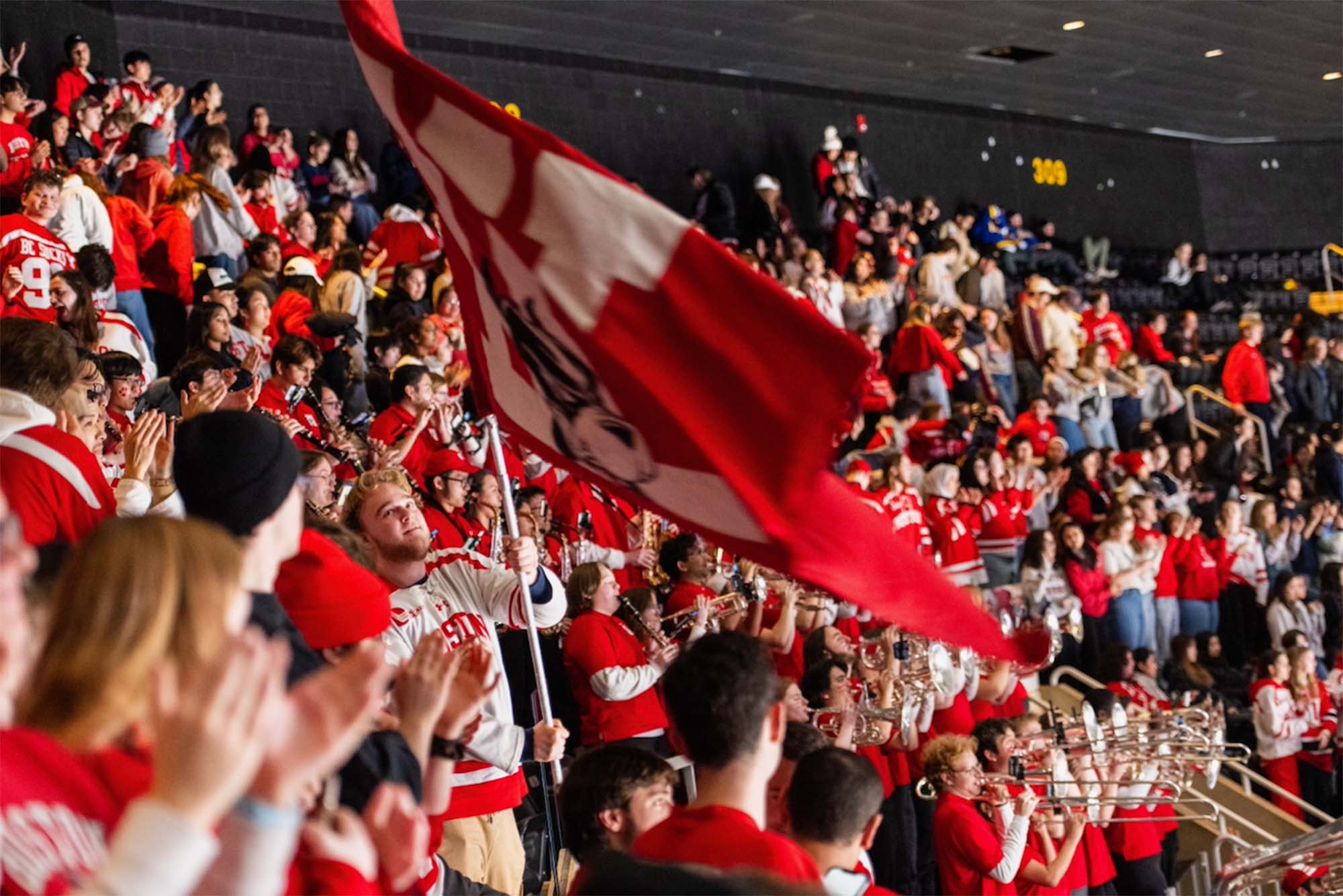 Photo: A fan waves a large red flag among a sea of red Boston University hockey jerseys in the crowd at the Beanpot semifinal game.