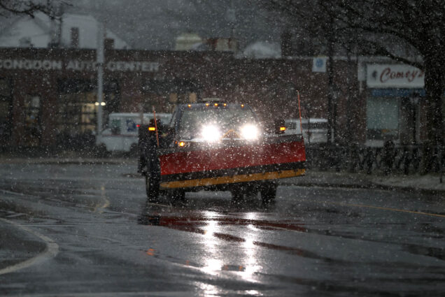 Photo: A plow truck rounds the Foxboro Common as snow begins to fall.