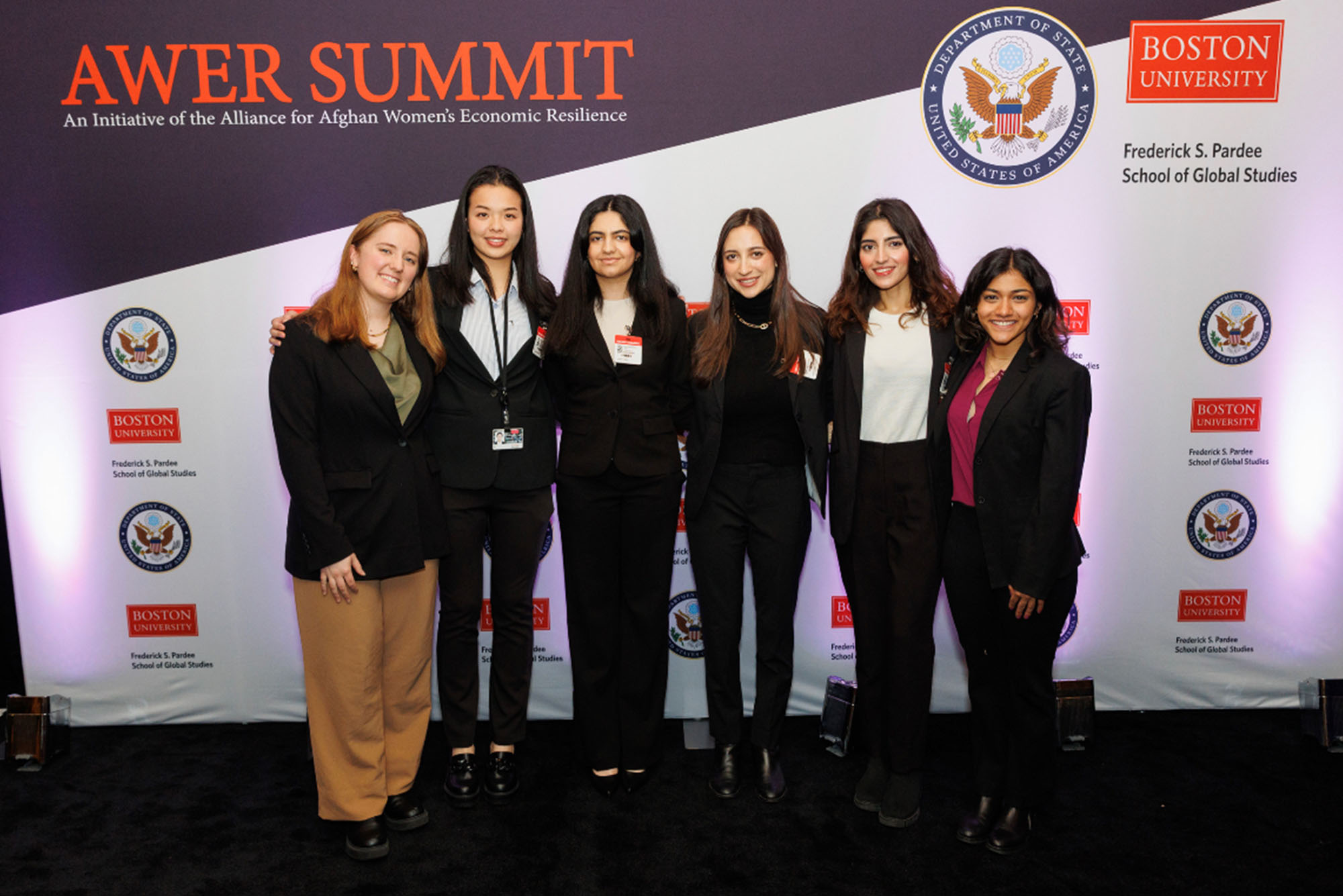 Photo: A group of college students in formal attire standing in front of a banner that reads "AWER SUMMIT"