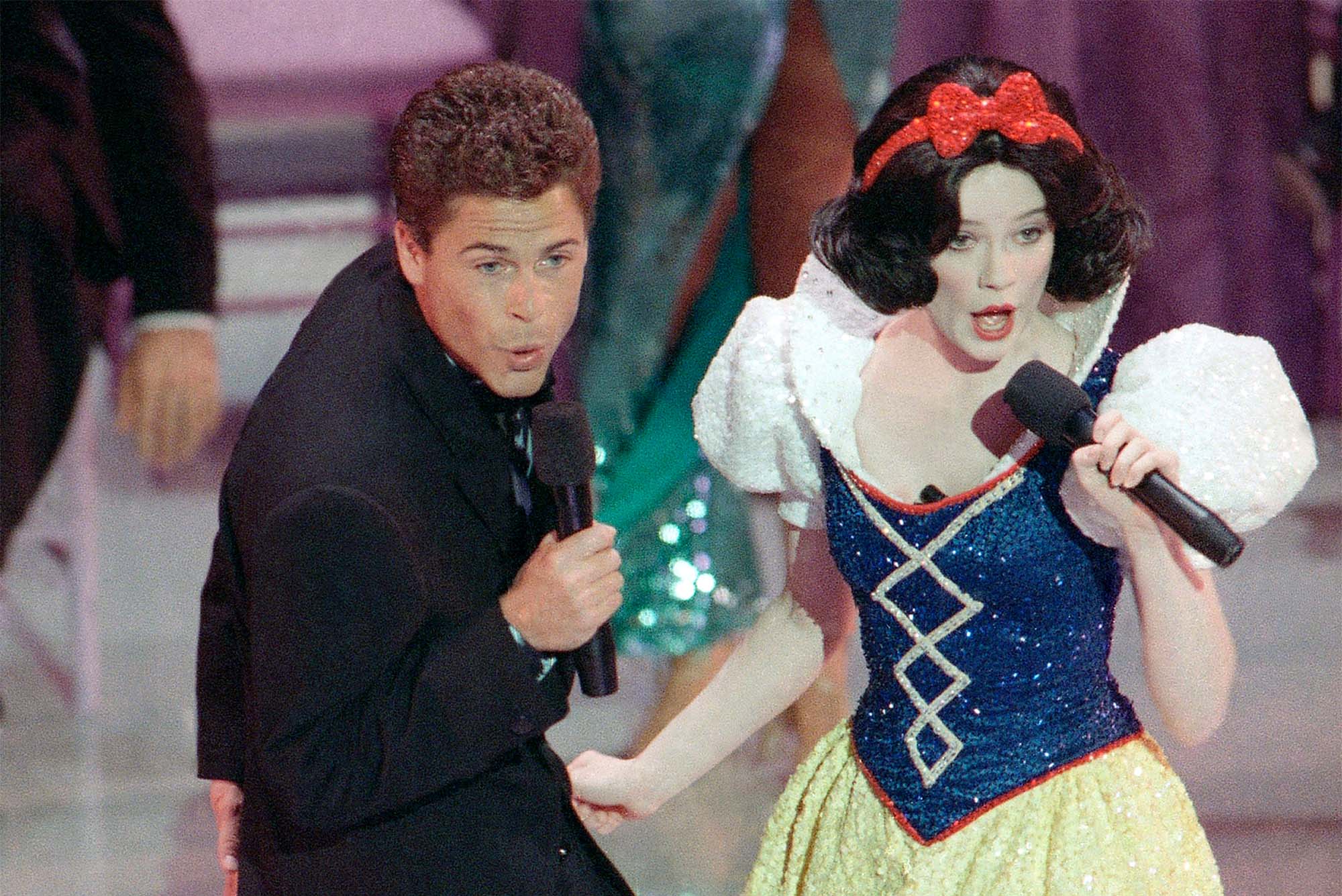 In this March 30, 1989 file photo, actor Rob Lowe croons a tune to Snow White during the opening number for the 61st Academy Awards presentation in Los Angeles. (AP Photo/ Reed Saxon, File)