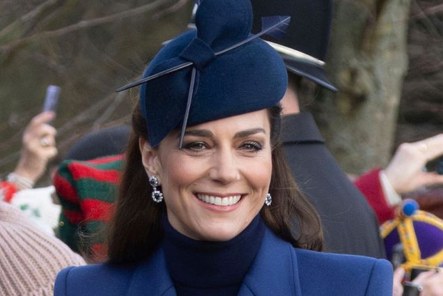 Photo: A picture of Kate Middleton wearing a blue hat and matching blue suit with a black shirt under