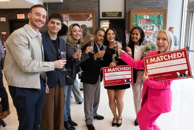 Photo: A group of well-dressed people holding champagne flutes. Two are holding signs that say "I Matched!"