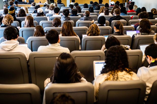 Photo: A college lecture classroom filled with kids, their backs to the camera.