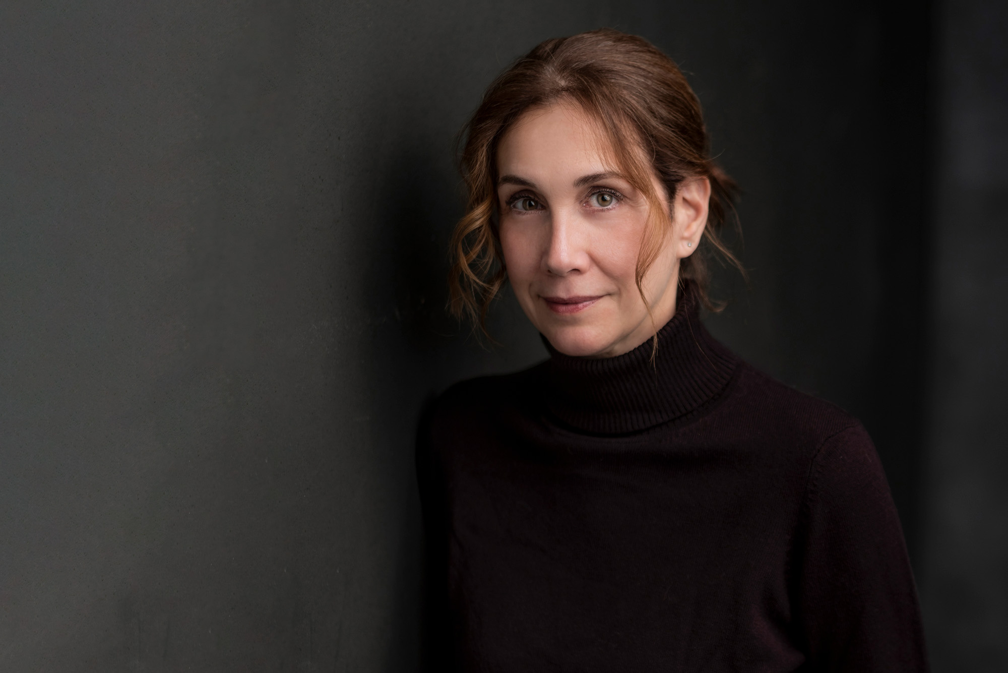 Photo: A portrait shot of Maria Smilios, a woman with her brown hair pulled into a bun.