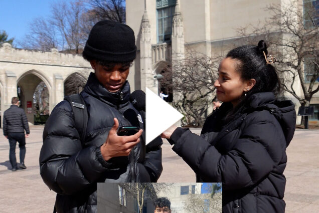 Photo: A woman holding a microphone up to the mouth of a black college student wearing a beanie. They appear to be conducting an interview. There is a white play button overlayed on top o the image