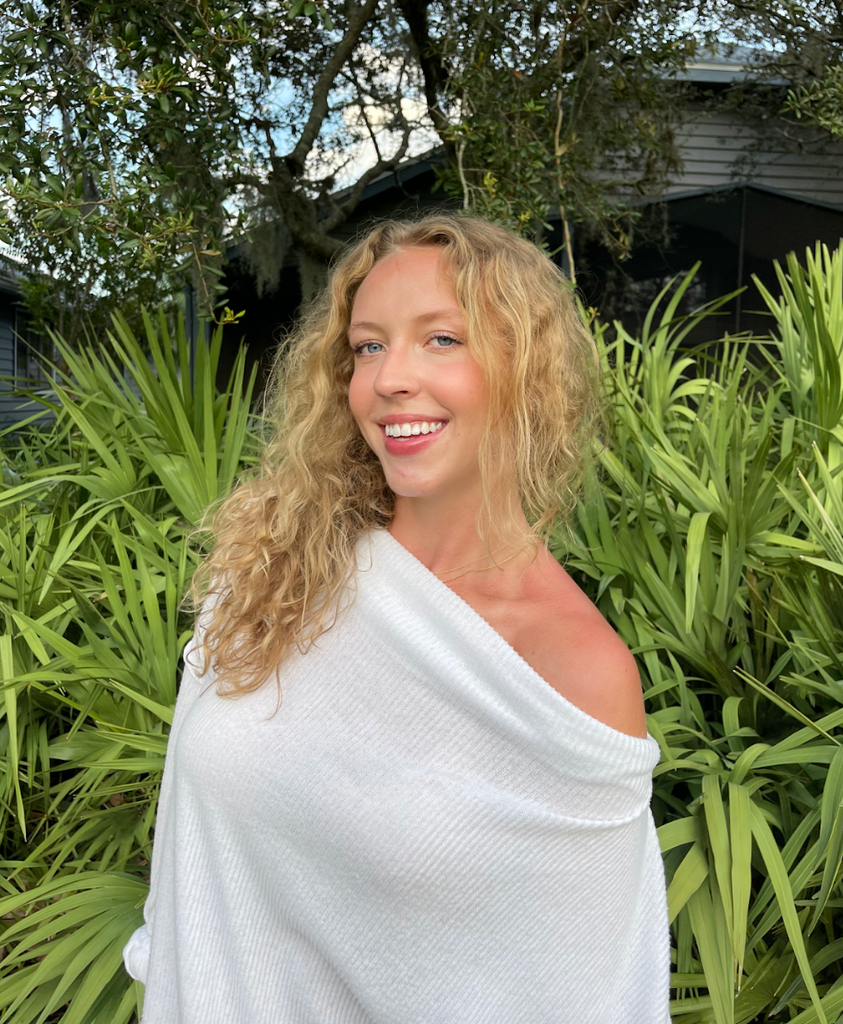 Boston University student Patricia Rueckert (Sargent ‘25). She is in front of greenery, with her blonde curly hair down, smiling at the camera.
