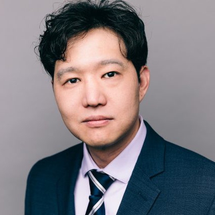 Photo: An asian man wearing a suit and tie poses for a formal portrait headshot