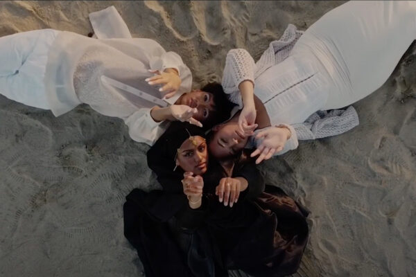 Photo: A picture of three people laying in the sand and looking up