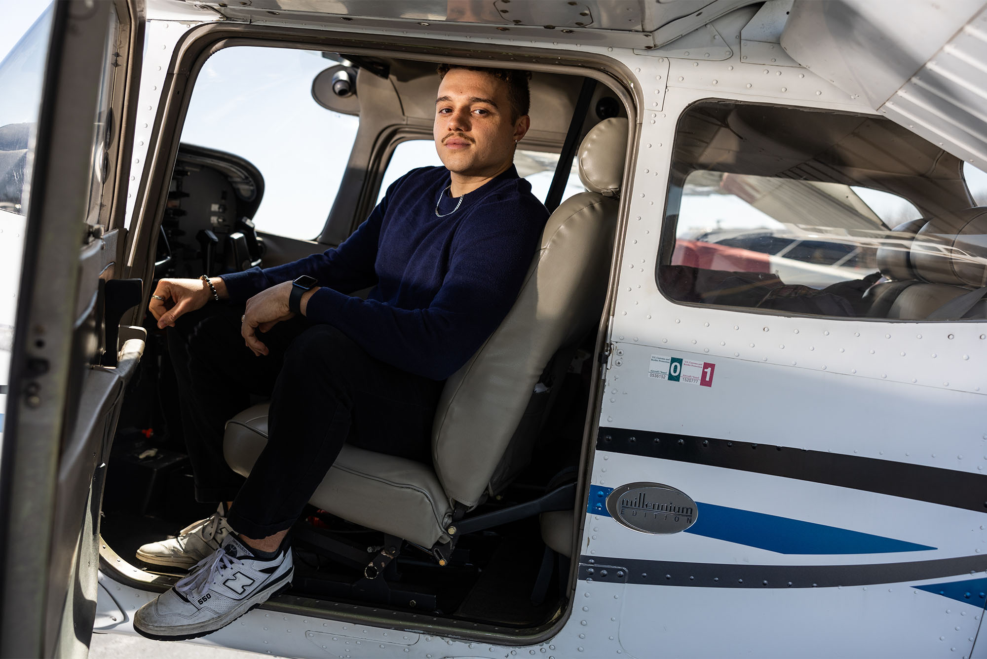 Photo: A young man sitting inside of a small Cessna plane