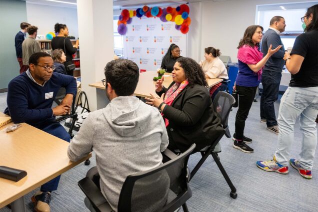 Photo: Small groups of people converse inside a new space for Diversity Equity and Inclusion at Boston University