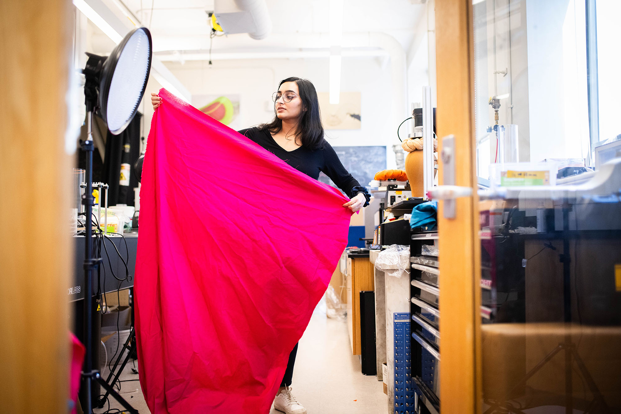 Photo: A picture of a woman holding a long piece of pink fabric