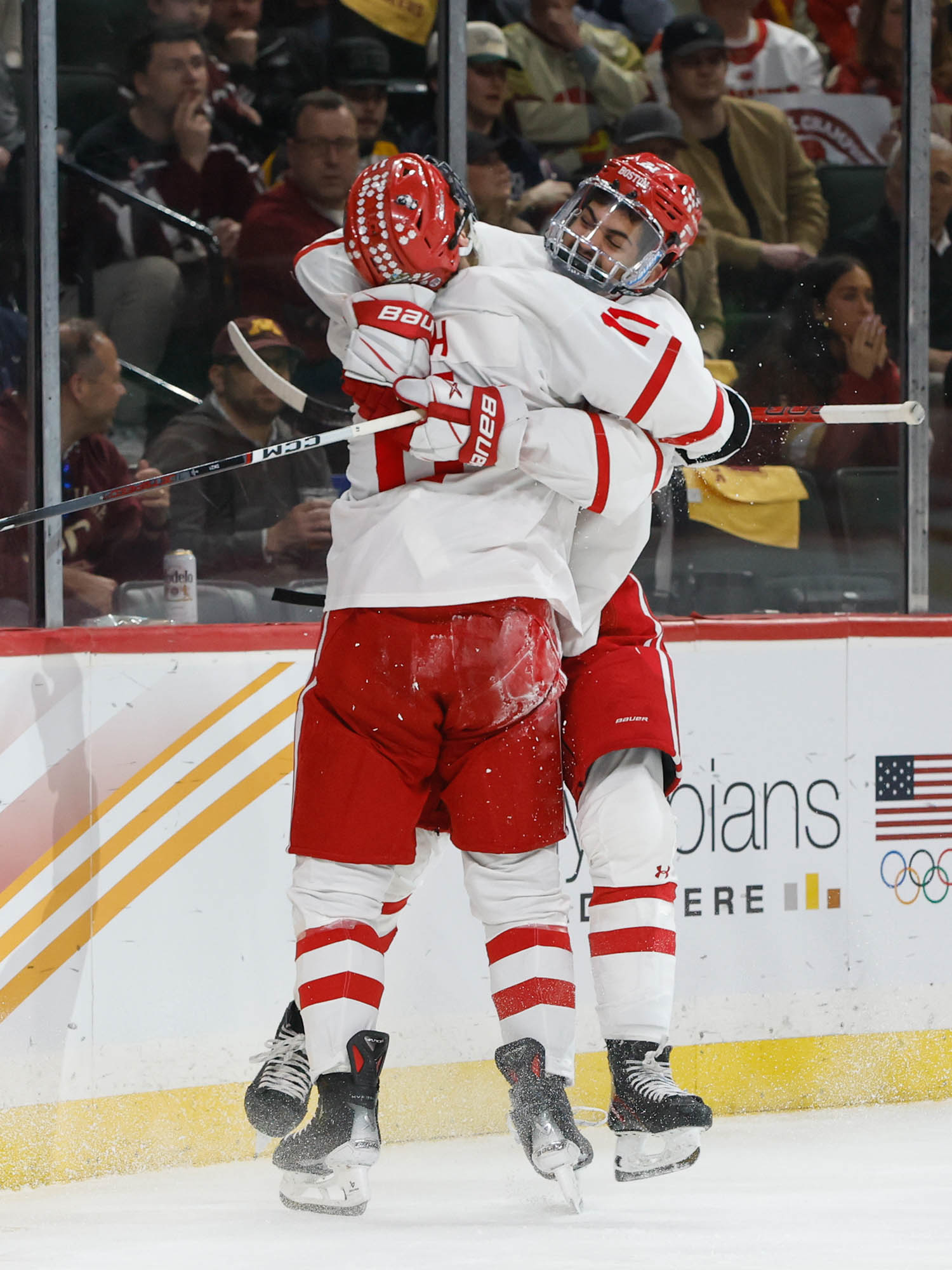 Photo: Two hockey players embrace in a tussle on the ice.