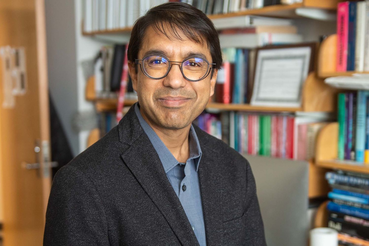 Photo: A picture of a man wearing glasses and a suit posing for the camera