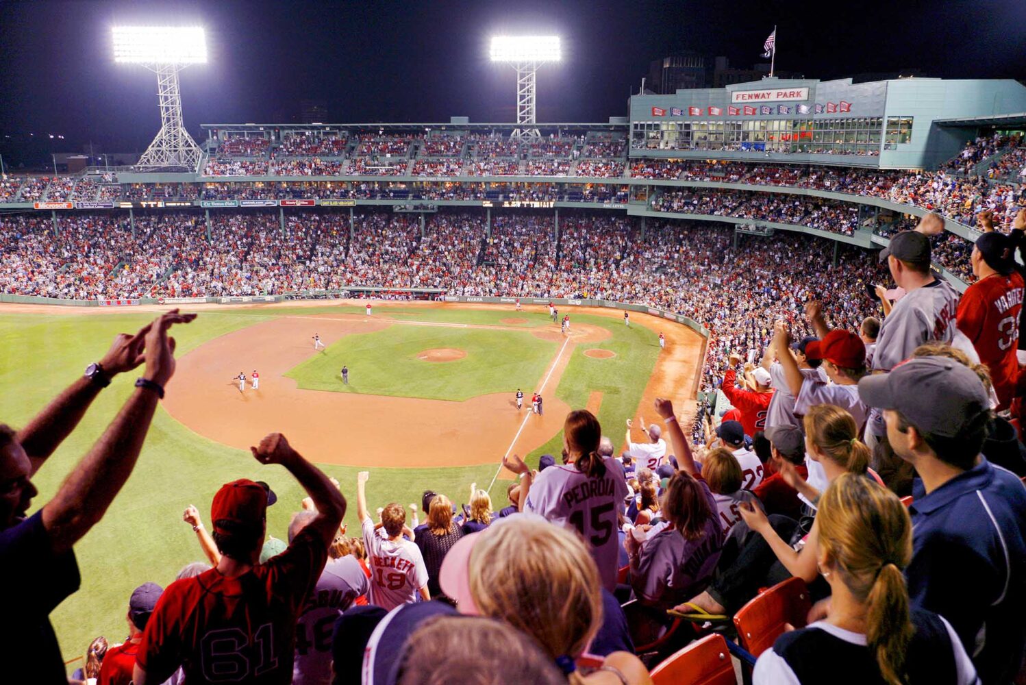 Photo: A wide shot of fans cheering at a game at Fenway stadium.