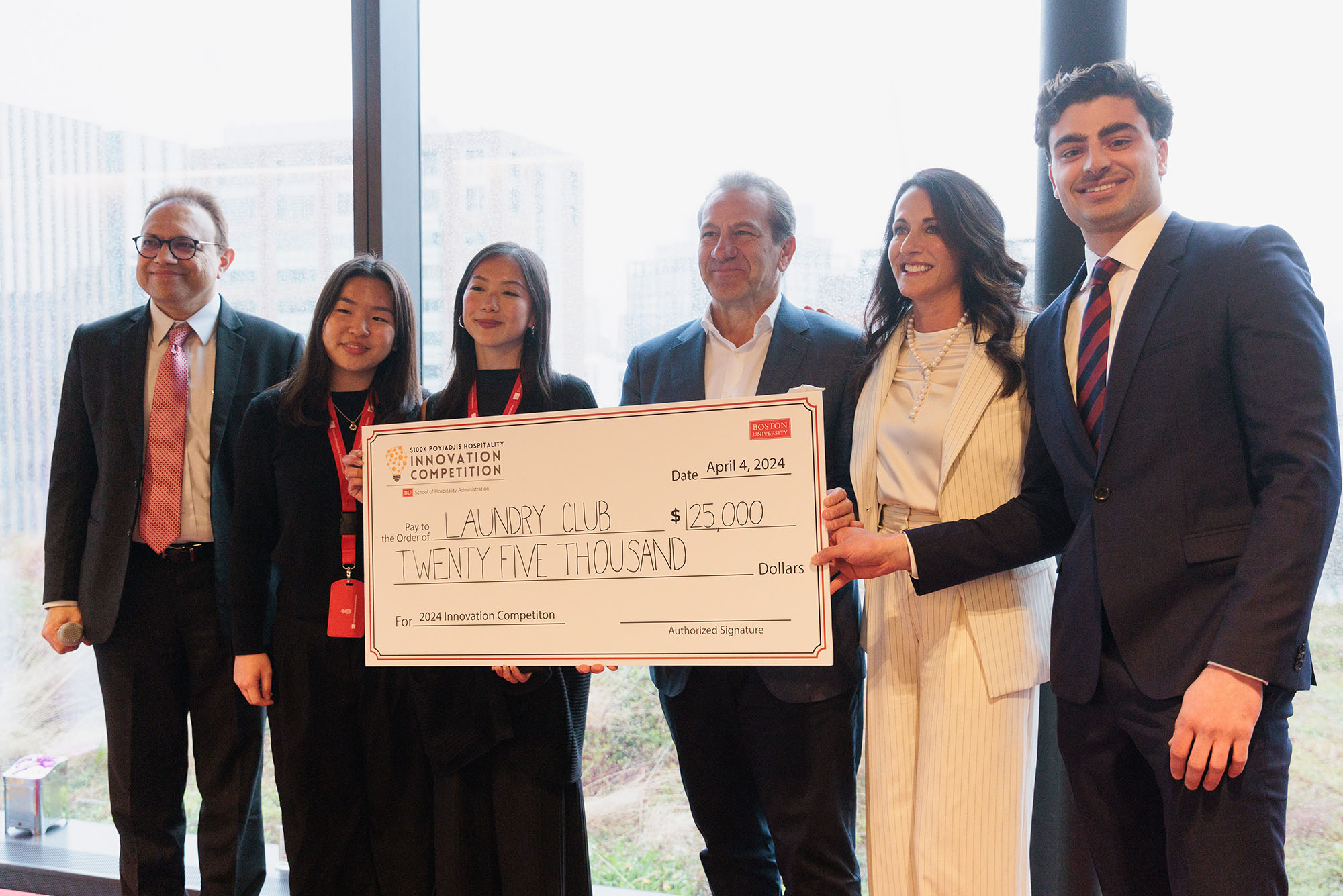 Photo: A picture of 6 people holding a large check for $25,000. They are dressed in formal attire