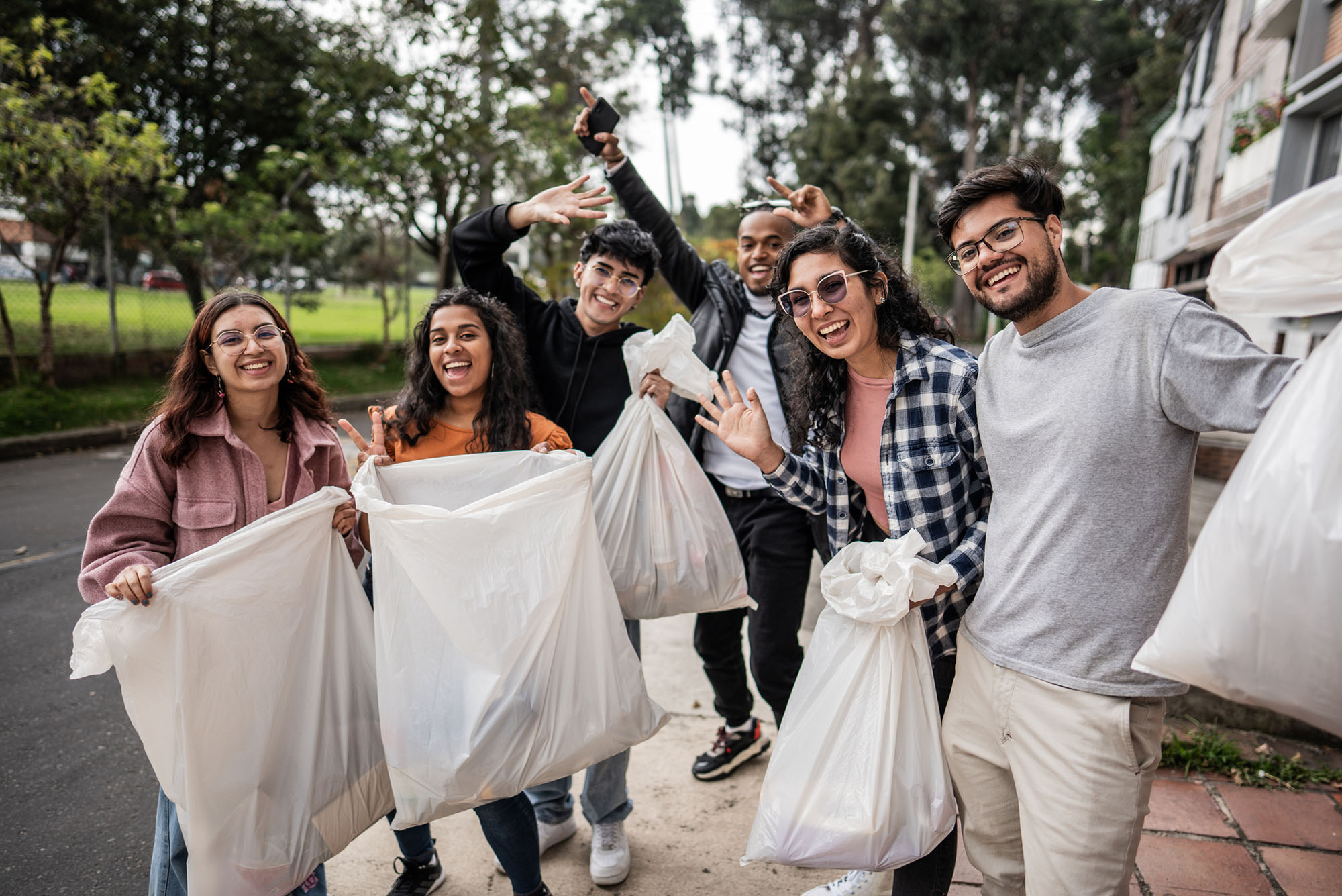 Photo: A picture of people holding up trash bags with items in them