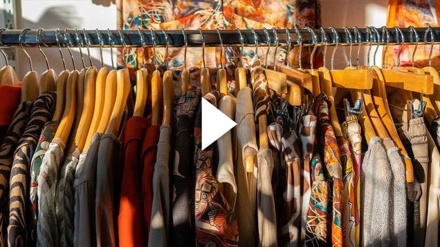 Photo: A rack of wooden hangers with items of clothing hanging off them.