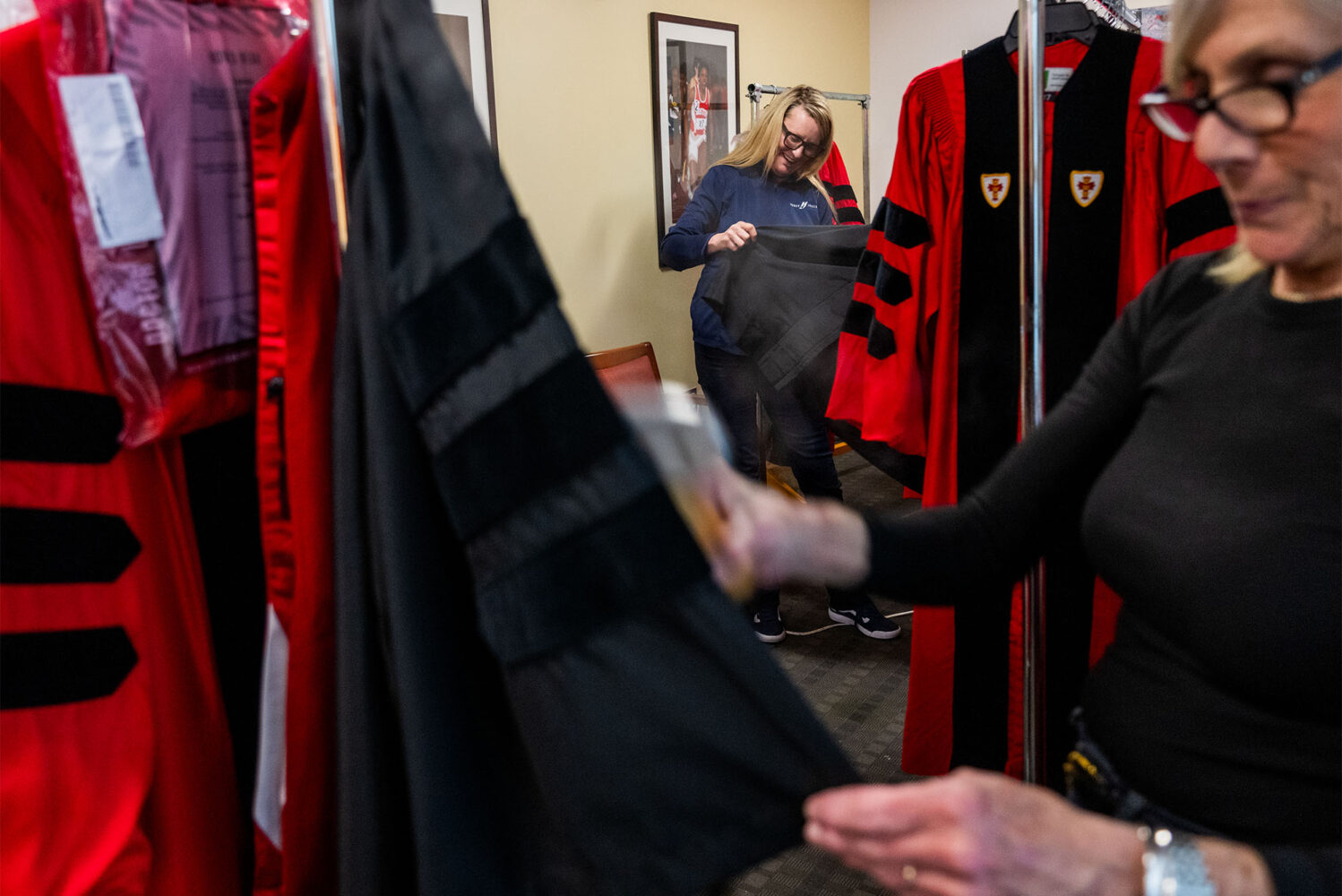 Photo: Brooke Sheerin (left), sales rep for Herff Jones, manufacturer of the caps and gowns used for BU commencements, steams robes with Auxiliaries Services institutional event specialist Judith Moran May 2 in the Athletic Offices.