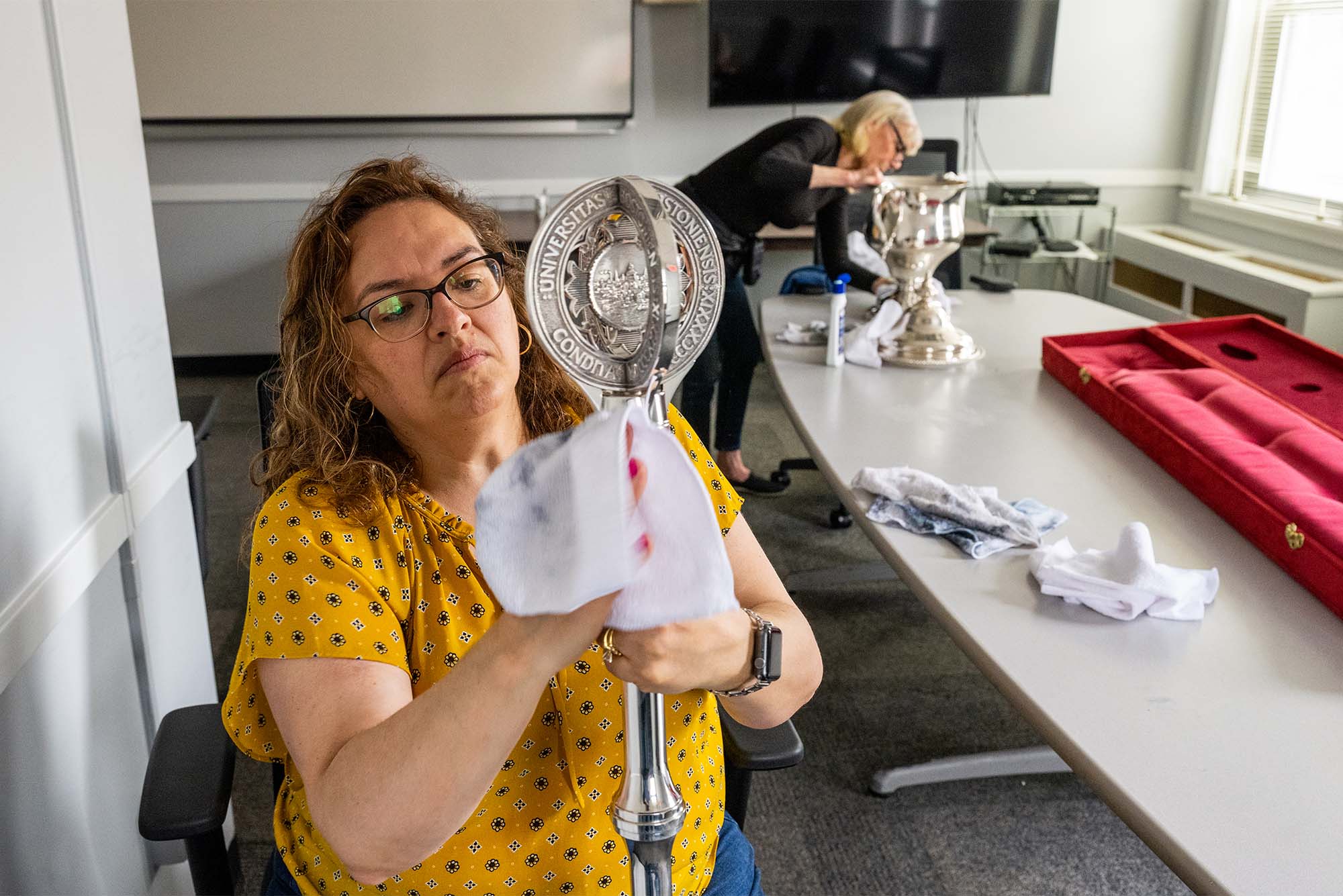 Photo: An employee polishes a traditional metal mace that is used ceremoniously at Boston University's commencement