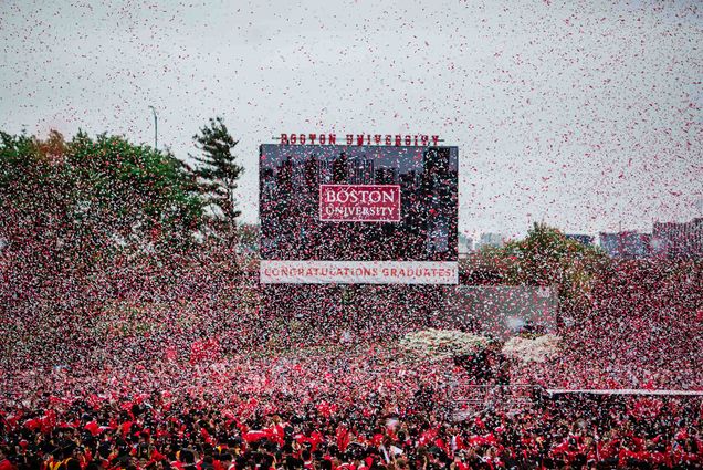 Photo: A sea of confetti over a large crowd of graduates in red gowns at the 2024 Boston University Commencement