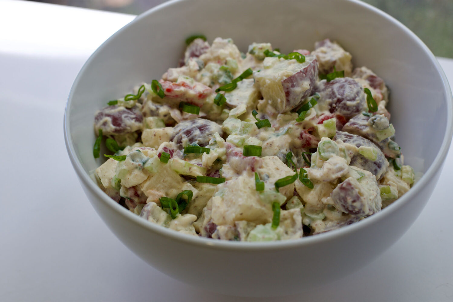 Photo: a large white bowl filled with potato salad