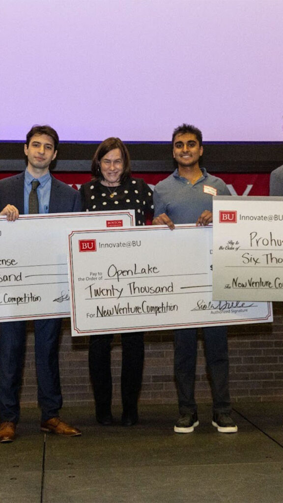 Photo: A group of students holding large checks at a recent innovation competition at Boston University