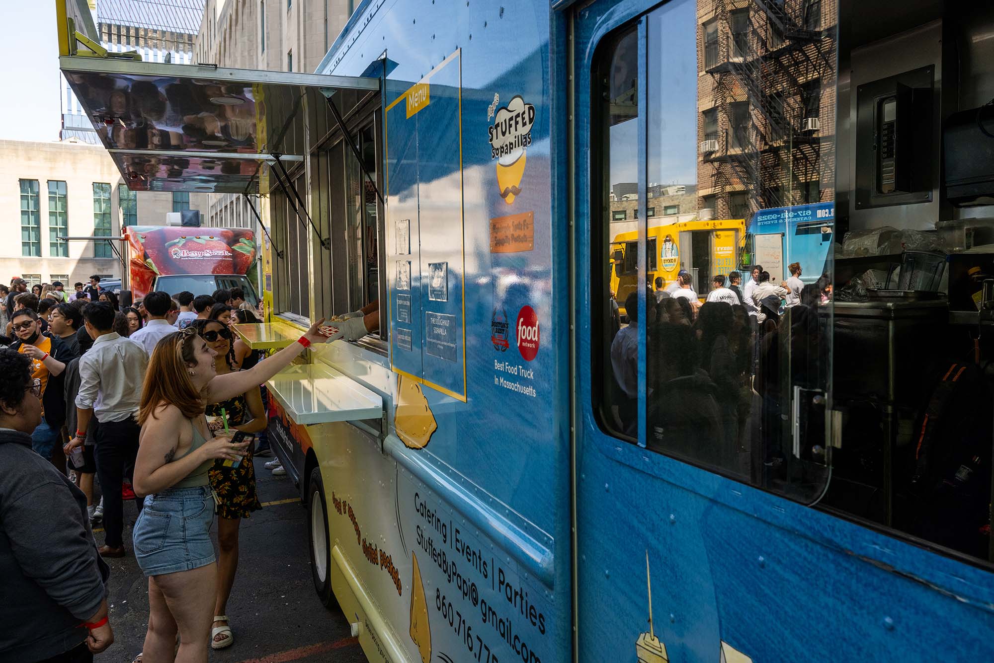 Photo: A picutre of a girl receiving an order from a blue food truck
