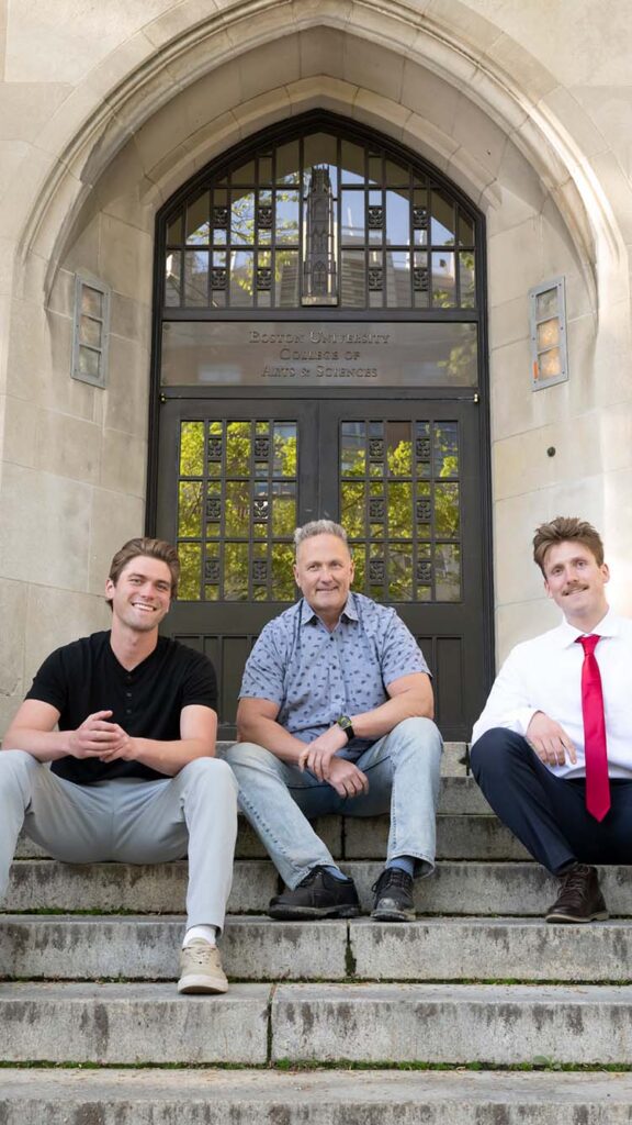 Photo: A picture of a father sitting on the steps with his sons on either side of them. The building behind them says "Boston University College of Arts & Sciences"