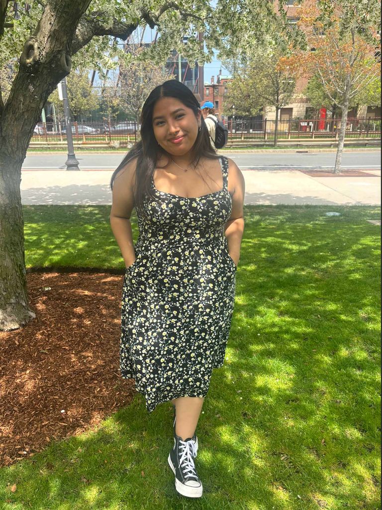 Photo: A picture of a girl with long, dark hearing wearing a black floral dress and black and white converse