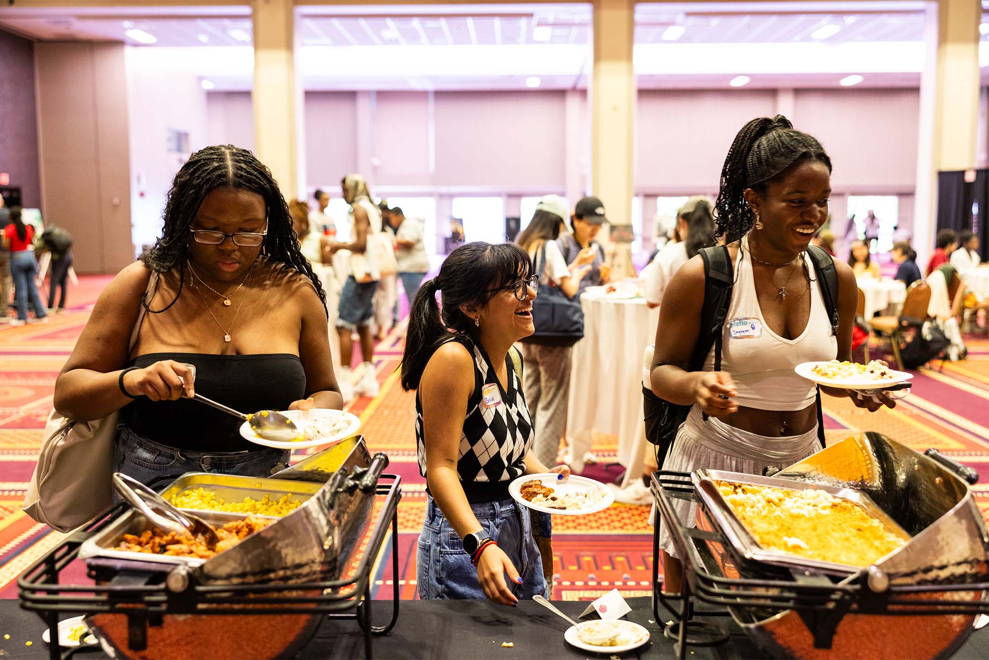 Photo: A group of college students helping themselves to a BBQ buffet at a Dean of Students Juneteenth BBQ at Boston University